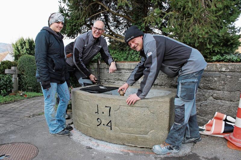 Haben den Brunnen saniert: Alina Kellerhals, Daniel Weber und Peter Rüegg. bär