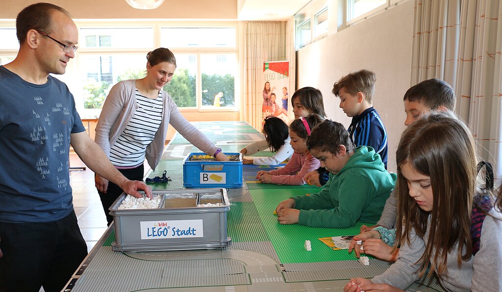 Michael Schatzmann und Irina Rindlisbacher bauen mit den Kindern Legohäuser.