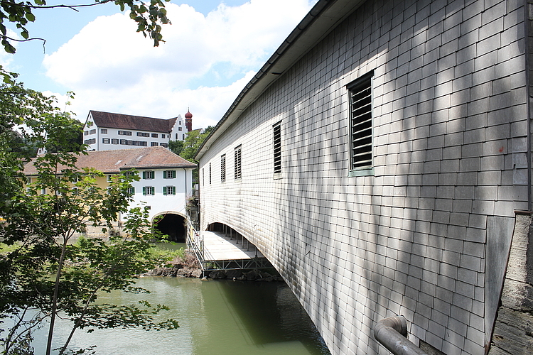 Die Holzbrücke, die Wettingen und Neuenhof verbindet, ist aussen mit Eternitschindeln verkleidet. Nach der Sanierung werden es wieder Holzschindeln sein. Rahel Bühler 
