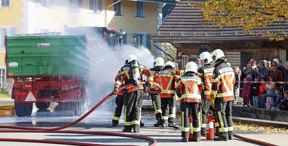 Das Feuer im Traktoranhänger wird mit Wasser,   Schaum und Pulver gelöscht.Gaby Kost