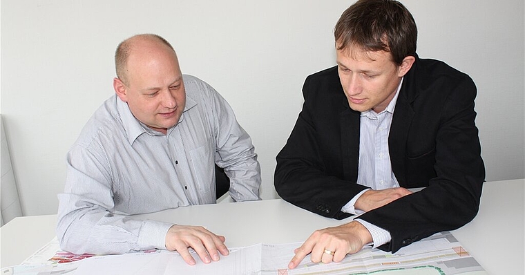 Gemeindeammann Valentin Schmid und Bauverwalter Oliver Lovisetto vor den Plänen des Rangierbahnhofs Limmattal mit Gatewayprojekt. Foto: bär