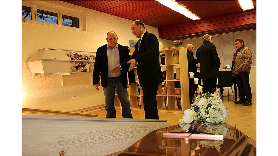 Roland Wunderli, Gesamtleiter der Badener Bestattungen, zeigt dem Spreitenbacher Ammann Vali Schmid am Tag der offenen Tür die verschiedenen Särge.Fotos: bär ... und Särge. Verschiedene Urnen ... 