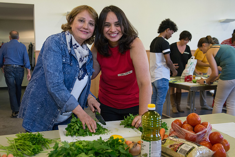 Noura und Valéria schneiden Gemüse.
