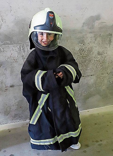 Der kleine Santiago in Brandschutzjacke und Helm.gk
