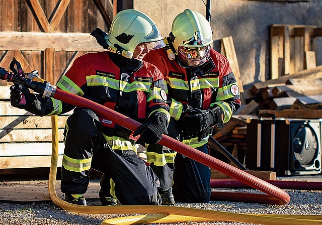 Die beiden Feuerwehrmänner sind konzentriert bei der Arbeit.