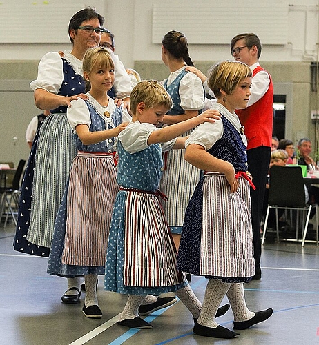 Die Kindertanzgruppe tanzt zusammen mit der Leiterin Marianne Temperli den Tatzelwurm.
