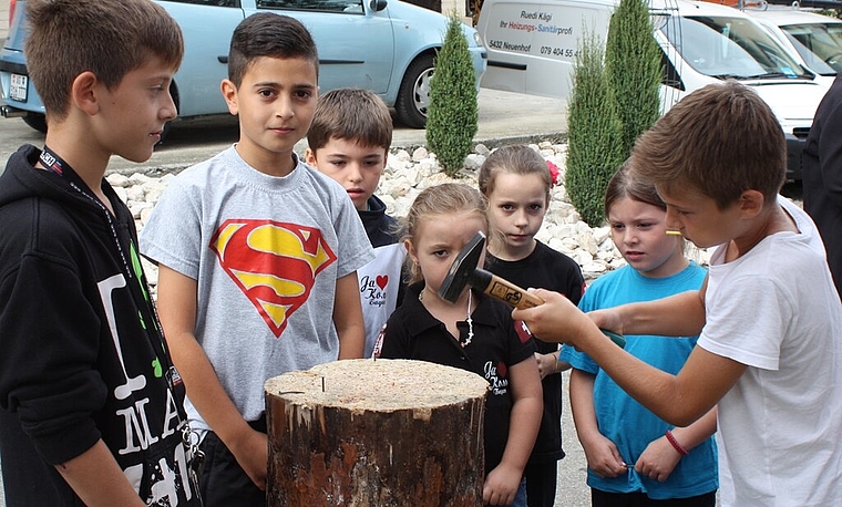 Alen (r.) am Stand der Jugendarbeit beim Nageleinschlagen.