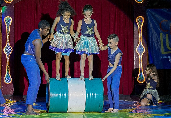 Hier ist Balance gefragt:<em> Die Kinder rollen mit einem Fass durch die Manege.</em>
