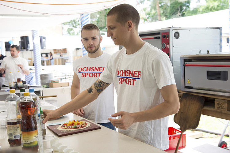 Fleissig werden Pizzas belegt. (bsc)