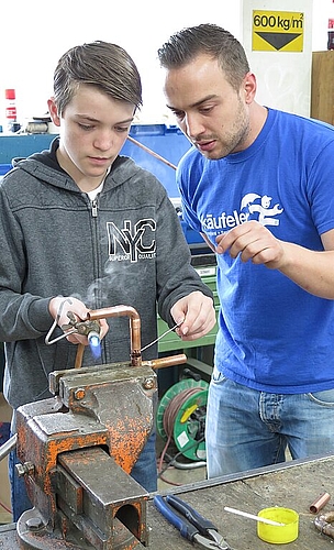 Löten Sanitärinstallateur Vlado Lopatko zeigt Oberstufenschüler Simon, wies geht.
