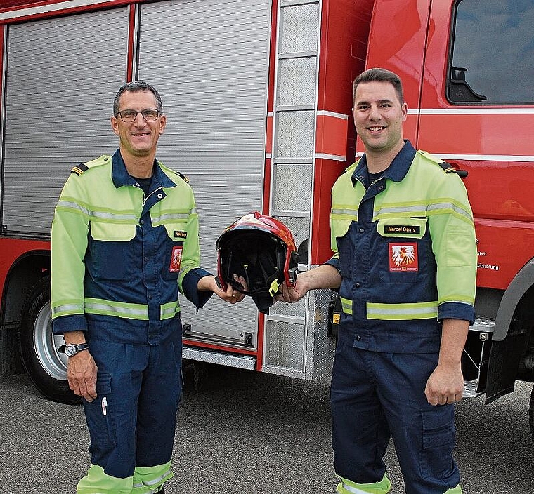 Feuerwehrkommandant Daniel Burger (links) gibt den roten Kommandantenhelm Marcel Gerny weiter. Rahel Bühler