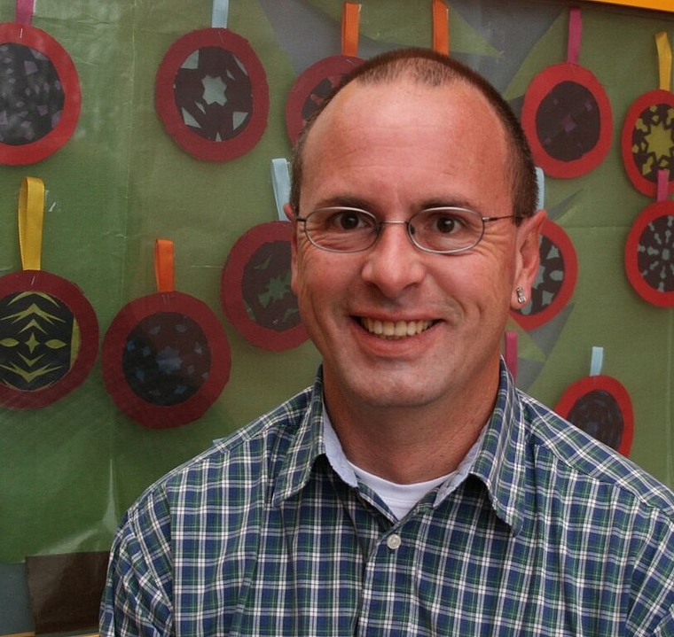 Schulpflegepräsident Rainer Carspecken vor dem Adventsfenster Nummer 3 der Primarschule Zelgli. Foto: ska