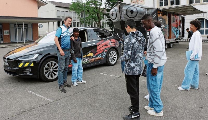 Louis Palmer ist bei den Jugendlichen beliebt,    sie posieren mit ihm vor dem Solarauto und dem «SolarButterfly»-Anhänger. Melanie Bär