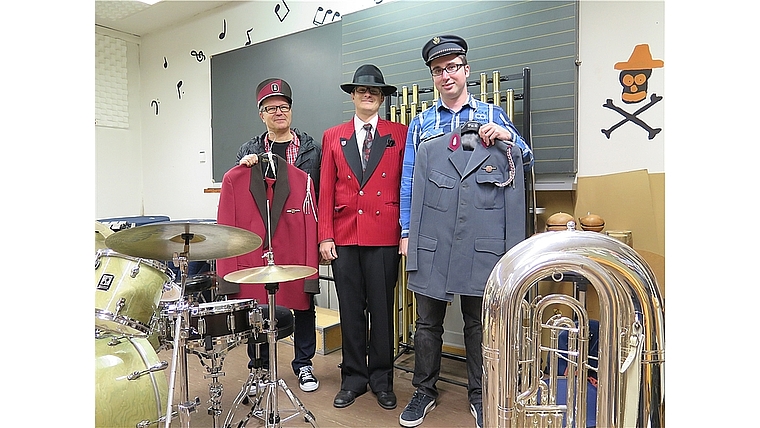 Geschichtsstunde bei der Musikgesellschaft Spreitenbach (v.l.): Saxofonist Antonio Amato mit dem Vorgängermodell, Aktuar Tobias Bendel in der aktuellen Jacke-und-Hut-Kombination und Kassier Fabian Hänni mit der ältesten Uniform. Foto: ska