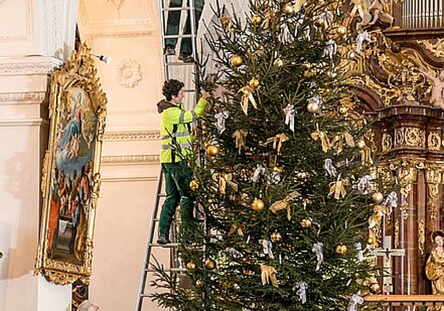 Beni Egloff, Katrin Cavigelli und David Saïdou <em>(v.u.) hängen den Weihnachtsschmuck an den Baum in der Klosterkirche. Sandra Ardizzone</em>