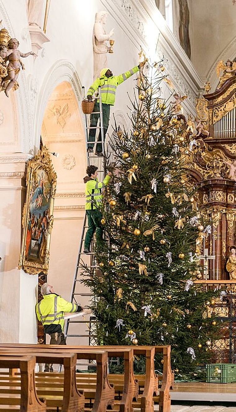 Beni Egloff, Katrin Cavigelli und David Saïdou <em>(v.u.) hängen den Weihnachtsschmuck an den Baum in der Klosterkirche. Sandra Ardizzone</em>
