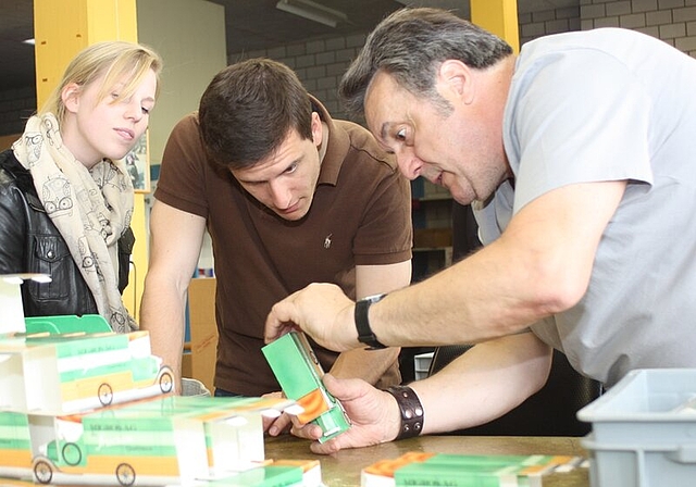 Felix Salzmann (r.) zeigt den Besuchern Mathias Welti und Nathalie Hofstetter in der Verpackungs-Werkstatt, wie man faltet.Foto: zVg