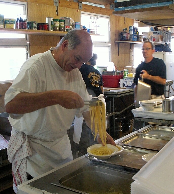 Ruedi Steffen schöpft in der eigens angebauten Küche Spaghetti für die hungrigen Spaghettata-Besucher. Foto: ska