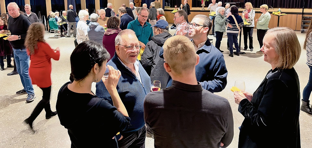 Die Gäste in der Aula stossen aufs neue Jahr an und unterhalten sich. Bilder: Ian Stewart