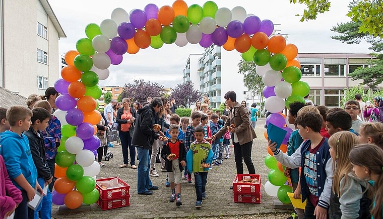 Unter einem bunten Luftballon-Bogen spazierten die jüngsten Schülerinnen und Schüler in die Runde. Foto: zVg