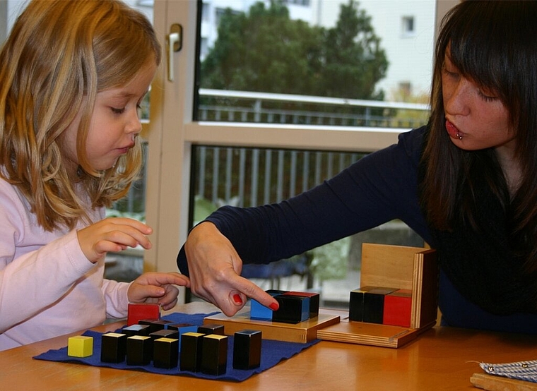 Mit Montessori-Materialien lernen die Kinder einfach: Stéphanie Gertiser erklärt Freja (5) die trinomischen Würfel. Foto: mbo