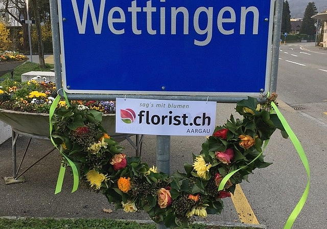 Zwei Lernende vom Wettinger Blumengeschäft Toscanini haben die Wettinger Ortstafel vergangene Woche mit Blumen dekoriert. zVg