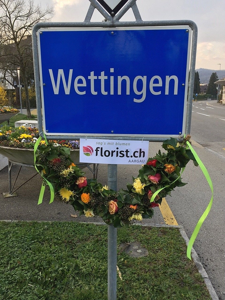 Zwei Lernende vom Wettinger Blumengeschäft Toscanini haben die Wettinger Ortstafel vergangene Woche mit Blumen dekoriert. zVg