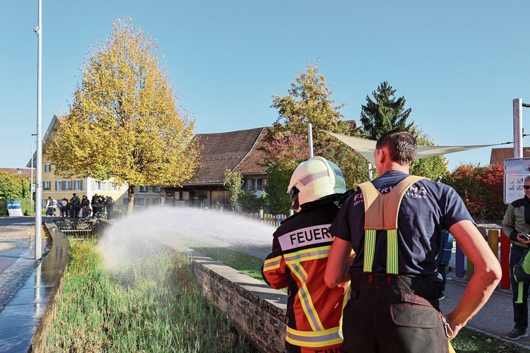 Eine Zuschauerin spritzt mit dem Wasserschlauch. gk
