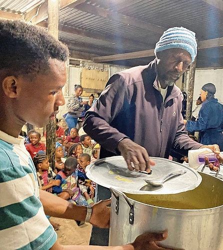 Pastor Fola kocht und verteilt Essen im Avian Park, Riyaad Booysen hilft beim Verteilen. Melanie Bär Pastor Fola kocht und verteilt Essen im Avian Park, Riyaad Booysen hilft beim Verteilen. Melanie Bär