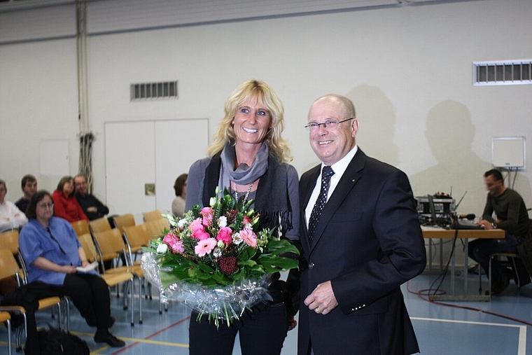 Gemeindeammann Walter Benz übergibt an der Gemeindeversammlung Blumen an die neu gewählte Susanne Schläpfer-Voser. Foto: bär