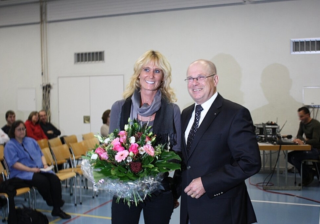 Gemeindeammann Walter Benz übergibt an der Gemeindeversammlung Blumen an die neu gewählte Susanne Schläpfer-Voser. Foto: bär
