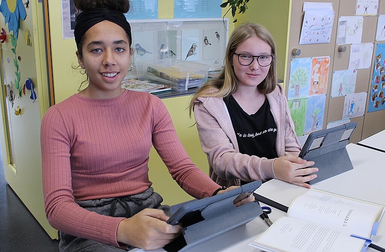 Sabrina Zobrist (l.) und Lena Funk gestalten mit iPads ein Rezeptbuch.
