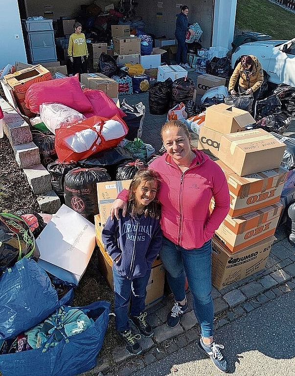 Goscha Zaranska steht mit ihrem Sohn Alex vor den vielen Hilfsgütern. Sibylle Egloff