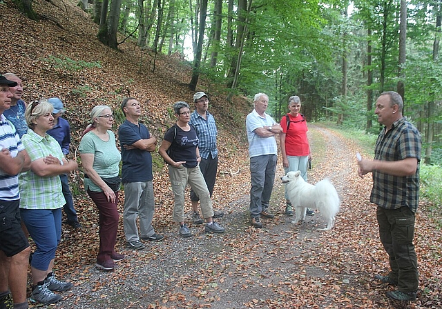 Gespannt <em>hören die Besucher den Ausführungen des Försters zu.</em>

