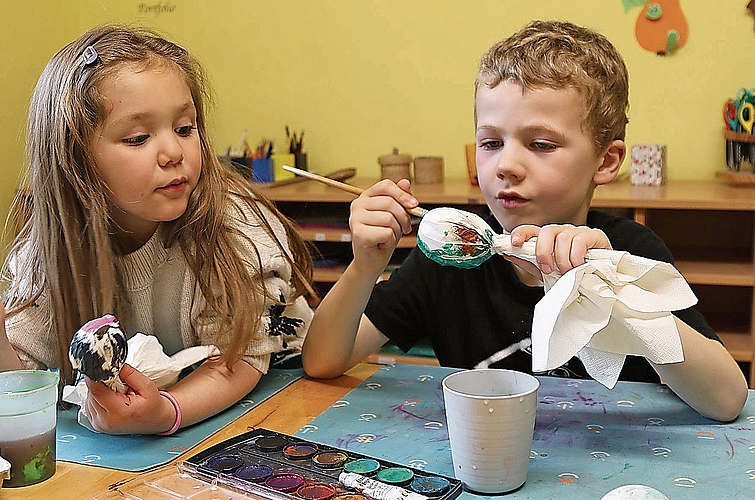 Mithilfe der Serviettentechnik bemalen die     Kinder die Eier.  Melanie Bär