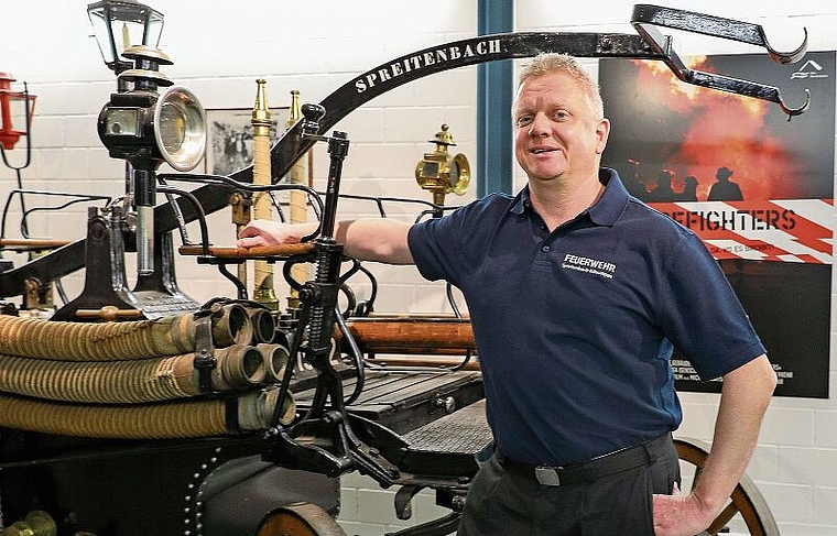 Sven Imboden vor der fast 120-jährigen Handdruckspritze im Magazin der Feuerwehr Spreitenbach-Killwangen.Gaby Kost