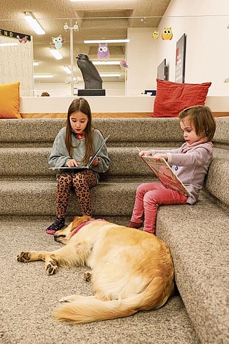 Die bald 10-jährige Eleonora (l.) liest Mila eine Geschichte vor, während die 4-jährige Elodie ein Bilderbuch anschaut. gk
