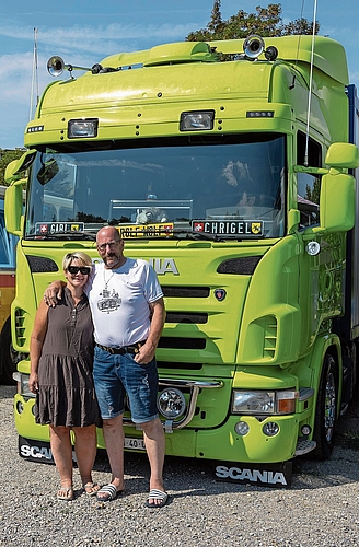 Gabi und Chrigel Oberhänsli vor ihrem Scania-Wohnlastwagen. Hinten führen sie ein Quad mit. 