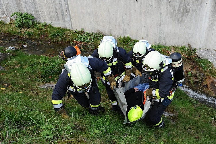 Die Feuerwehr birgt den «Verletzten» aus dem Bachbett.  Fotos: pn