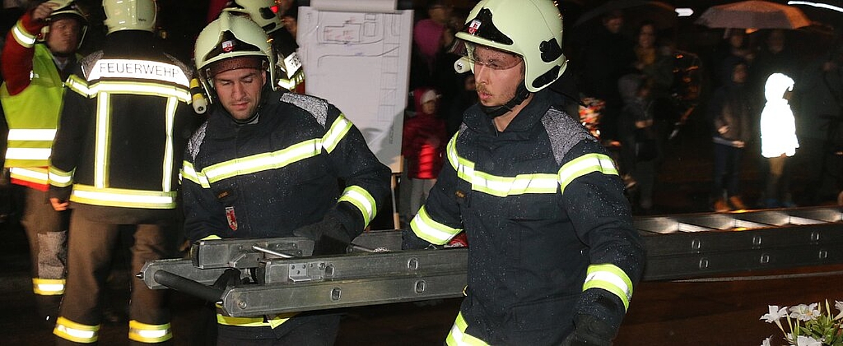 Mit der Leiter holen die Feuerwehrmänner die eingeschlossenen Bewohner aus dem Mehrfamilienhaus an der Dorfstrasse 1. Melanie Bär
