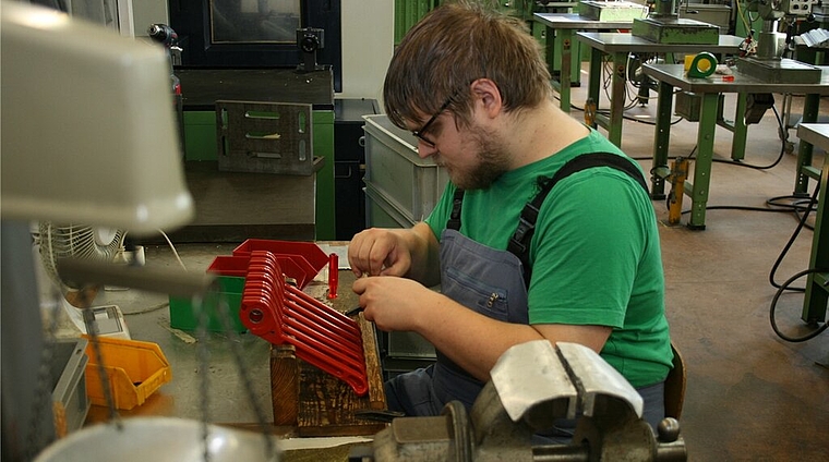 Martin Cathrein setzt in der Werkstatt spezielles Werkzeug für Kabelbinder zusammen. Trotz Momenten der Monotonie weiss er seine Stelle, seinen Chef und seine Mitarbeiter zu schätzen, wie er selber sagt. Foto: ska