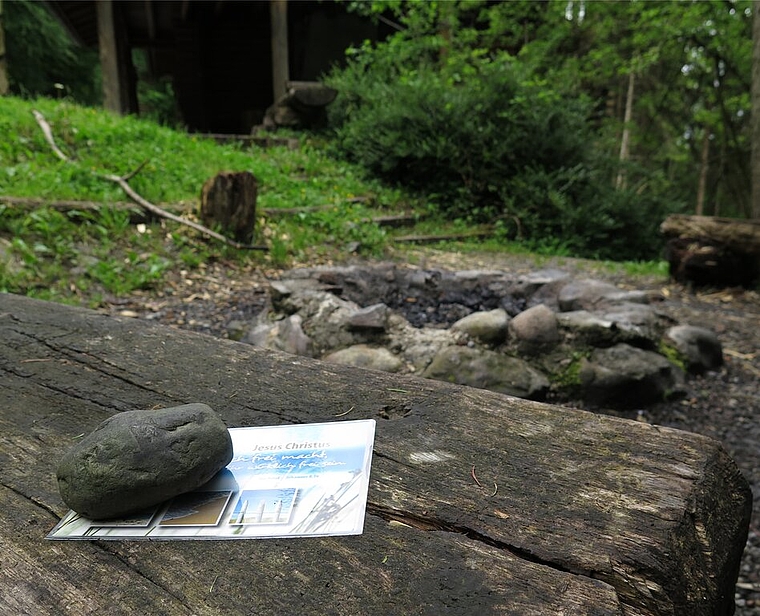 Ein Unbekannter legt laminierte Postkarten von religiösem Inhalt, mit einem Stein beschwert, im Spreitenbacher Wald auf Bänkchen. Zum Beispiel an der Feuerstelle bei der Waldhütte. Foto (nachgestellt): Mü
