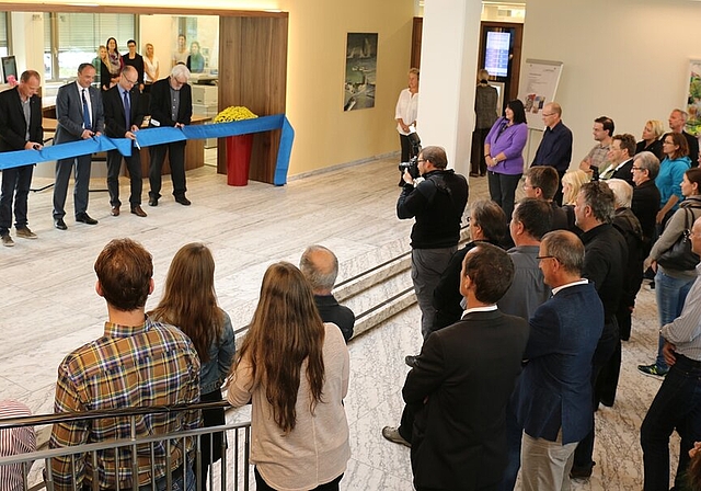 Politiker und Architekten durchschneiden das Band vor dem neuen Gemeindebüro. Foto: bär