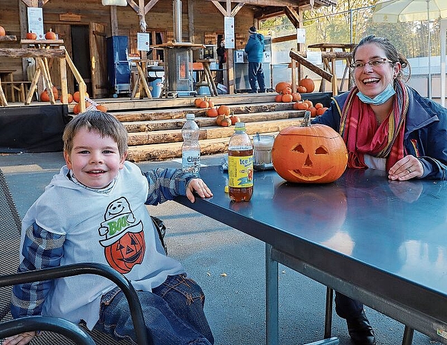Angie und Leon Hunziker schnitzen einen Kürbis vor dem Fondue-Chalet.