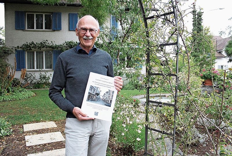 Der 71-jährige Historiker Benno Bruggisser vor seinem Einfamilienhaus in Wettingen. In den Händen hält er das Produkt seiner siebenjährigen Forschung: ein 200 Seiten starkes Buch. Rahel Bühler