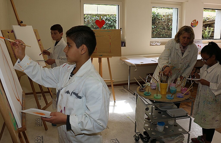 Nouraldin, Axad und Naaema (v.l.) mit Alice Tassinari in den Räumlichkeiten der Reformierten Kirchgemeinde. bär