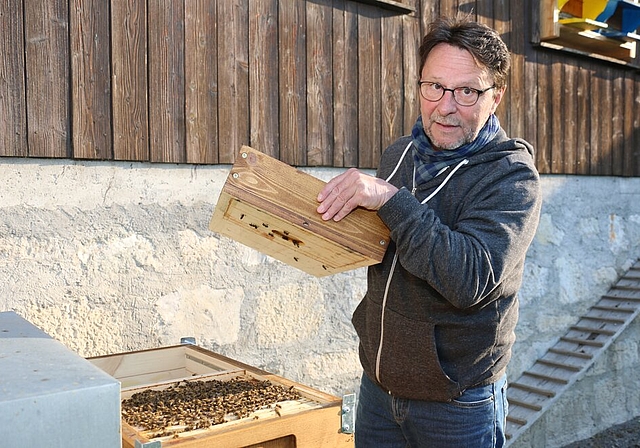 Dani Schwab gibt vor dem Bienenhaus Einblick in einen Magazinkasten.
