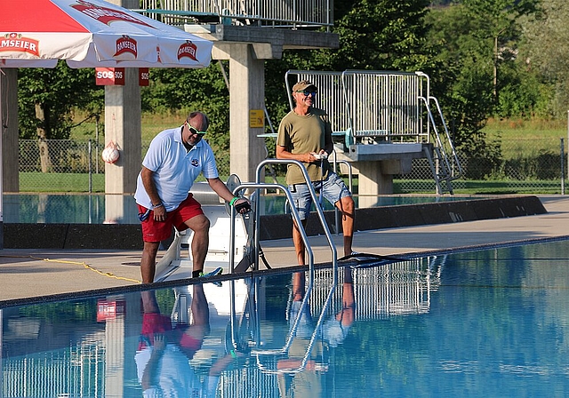 Badmeister Dieter Sutter und Markus Ernst (r.) <em>reinigen am Morgen kurz nach sieben das Freibad. (Melanie Bär)</em>

