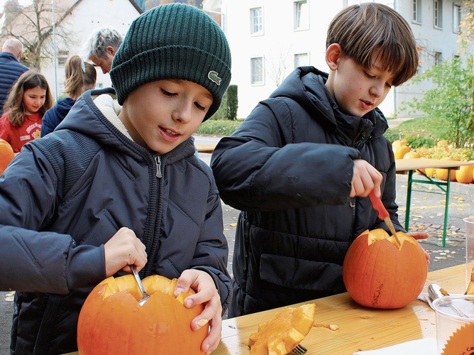 Ronel (l.) und Ajan schnitzen aus dem Kürbis eine Laterne. bär Ronel (l.) und Ajan schnitzen aus dem Kürbis eine Laterne. bär