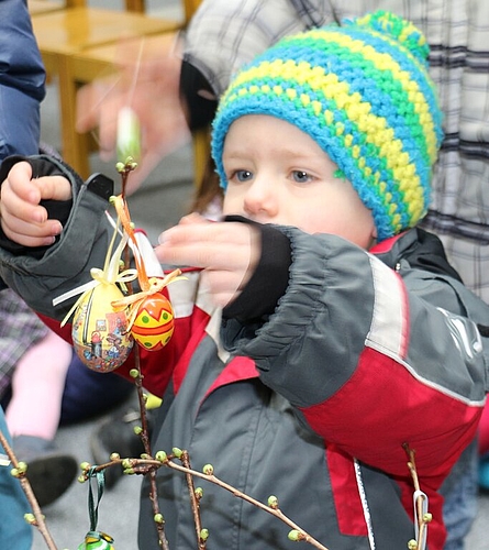 Levi hängt das Ei an den Osterbaum.